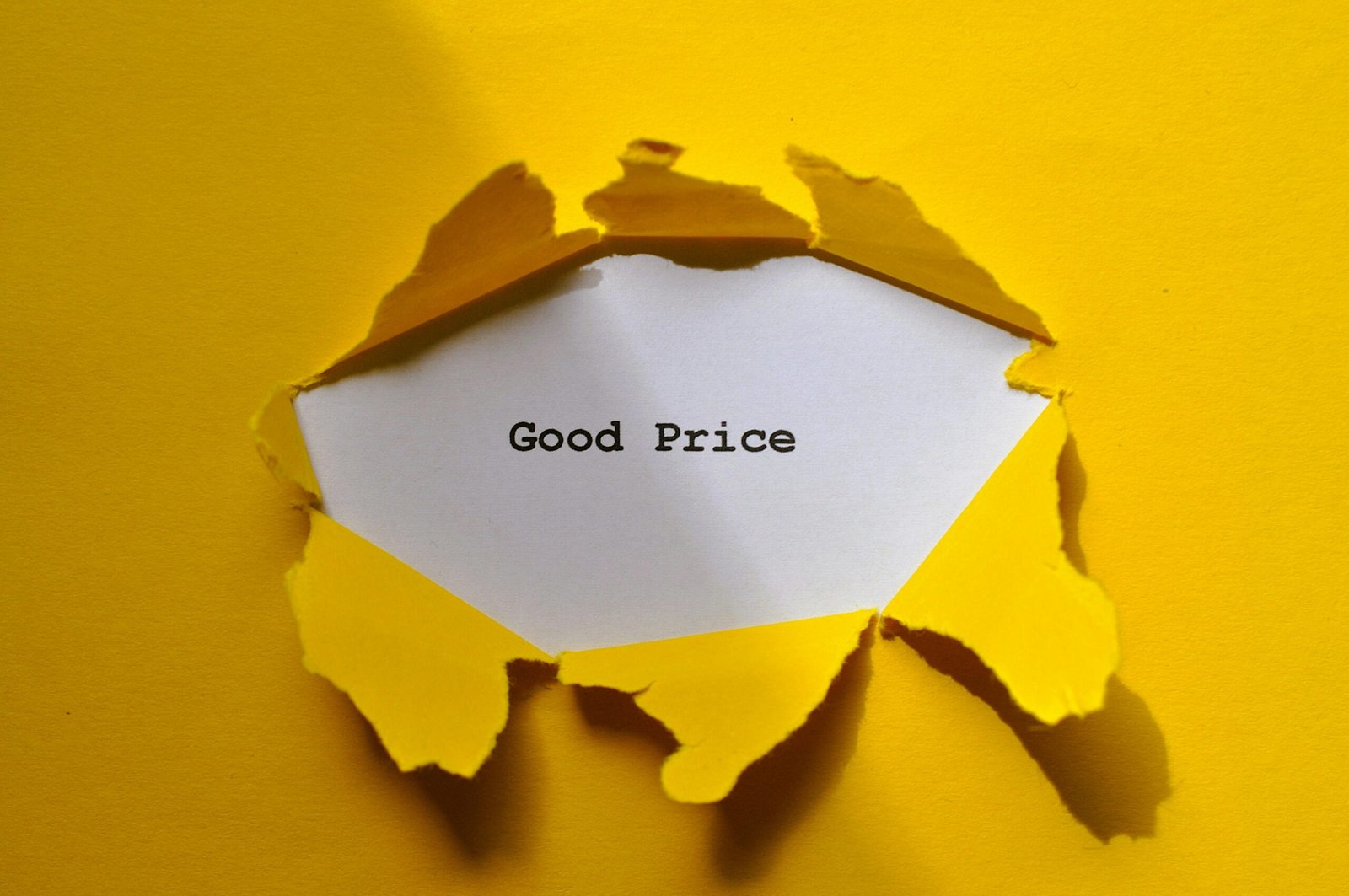 Yellow torn paper revealing 'Good Price' text, perfect for sales and marketing themes.