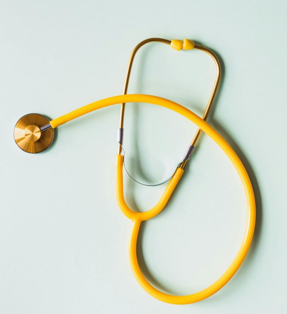Top view of yellow medical stethoscope placed on white surface during coronavirus pandemic